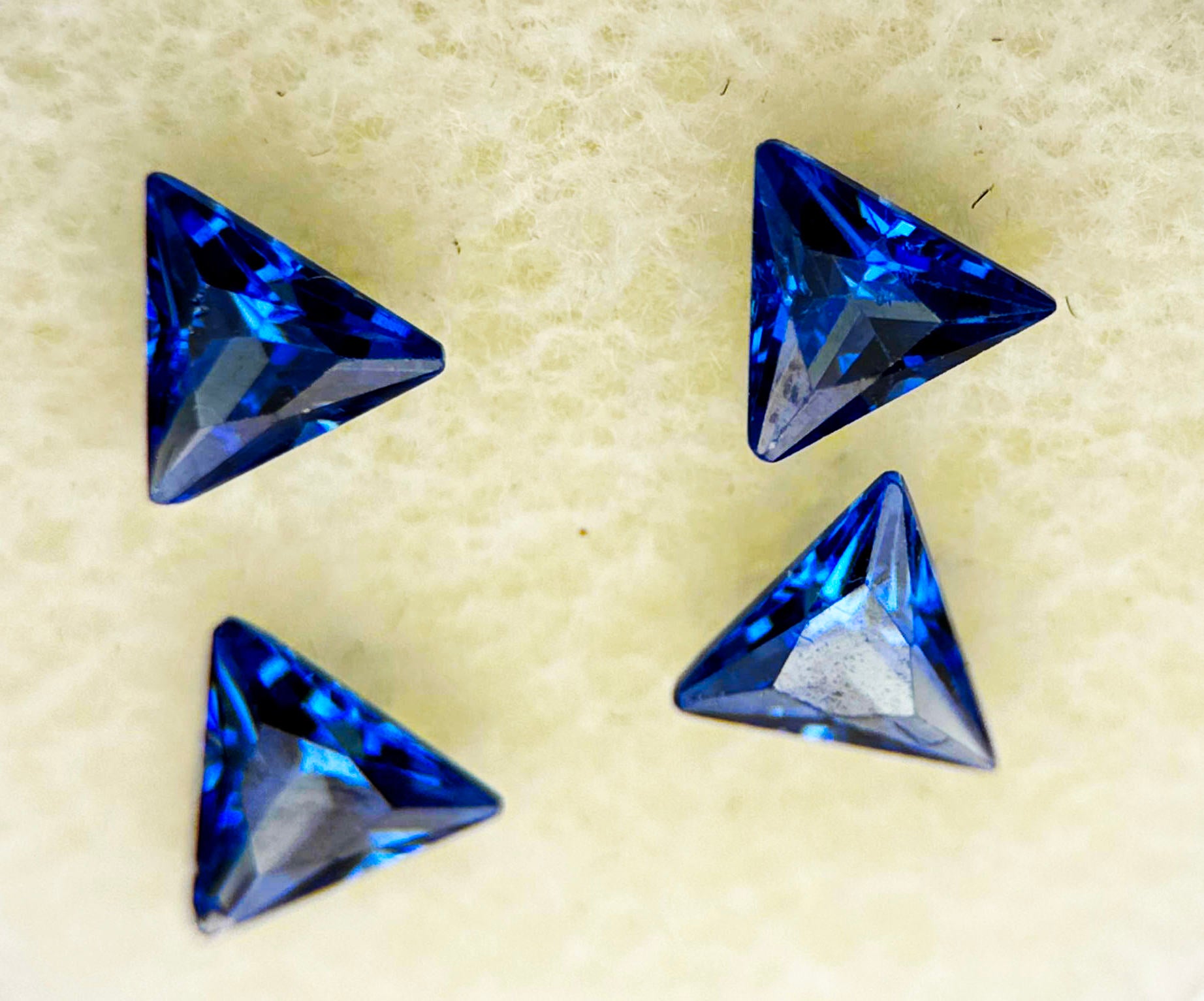 Four blue triangle sapphires, total 1.93 carats, IF clarity, standard heated